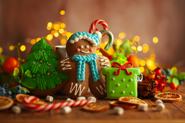 Weihnachtslebkuchenplätzchen mit Weihnachtsdekorationen auf hölzernem Hintergrund.