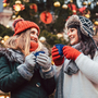 beste Freunde genießen Glühwein auf dem Weihnachtsmarkt